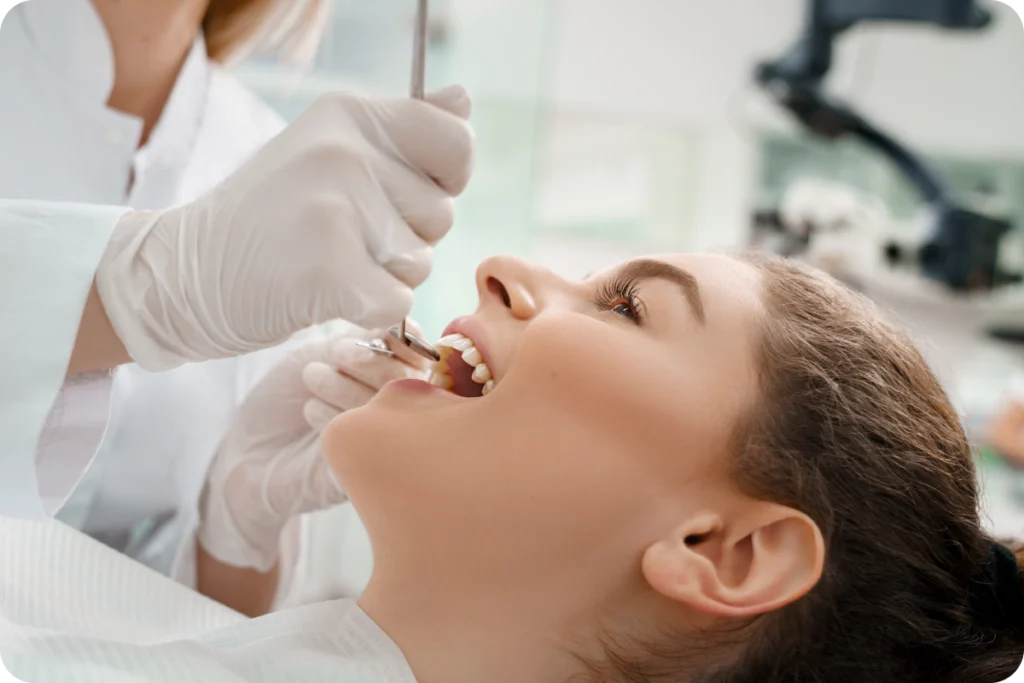Praticien examinant la bouche d'une patiente au fauteuil